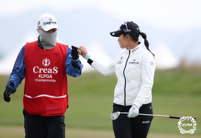 박현경이 1번홀에서 버디를 기록한 뒤 캐디로 나선 아버지와 주먹을 맞대며 기뻐하고 있다. (사진=KLPGA)