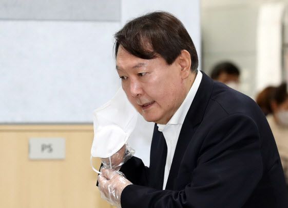 윤석열 전 검찰총장이 4·7 서울시장 보궐선거 사전투표 첫날인 4월 2일 서울 서대문구 남가좌1동 주민센터에 마련된 사전투표소에서 신분 확인을 위해 마스크를 내리고 있다.(사진=연합뉴스)