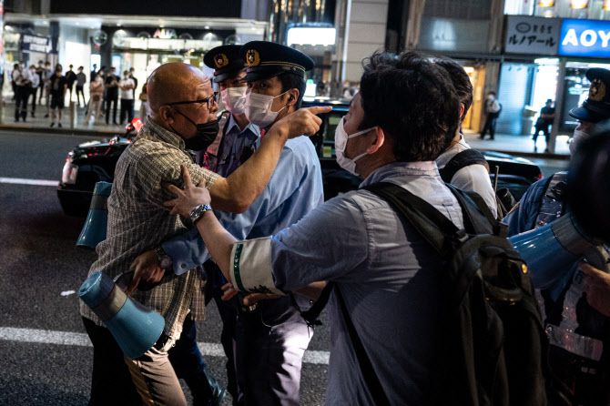 경찰이 지난달 23일 도쿄에서 올림픽에 반대하는 시위대를 제지하고 있다(사진=AFP)