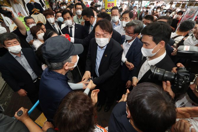 윤석열 전 검찰총장이 20일 오후 대구 중구 서문시장을 찾아 상인들과 인사하고 있다. (사진=연합뉴스)