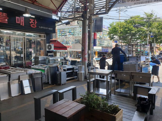 폐업 점포에서 실어온 중고주방기기 물건들을 인부들이 실어 내리고 있다. (사진=김호준 기자)