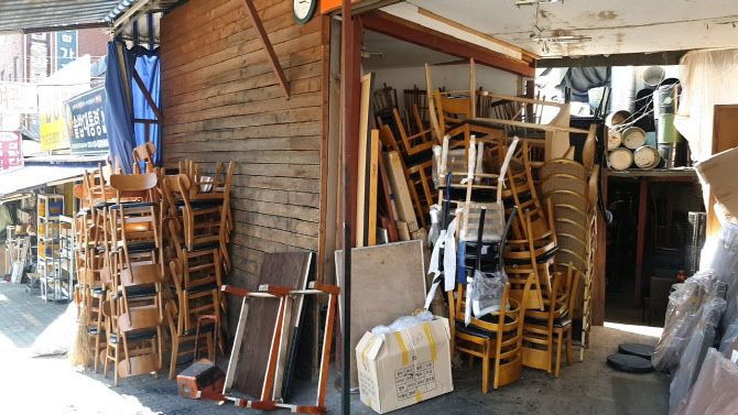 황학동 주방거리에 있는 한 중고가구 업체에 폐업 점포에서 쓰던 의자 등 가구류들이 산더미처럼 쌓여 있다. (사진=김호준 기자)
