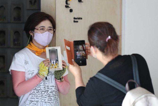 27일 오전 서울 광화문 세월호 기억공간에서 유가족이 아이의 사진과 함께 촬영하고 있다.(사진=연합뉴스)