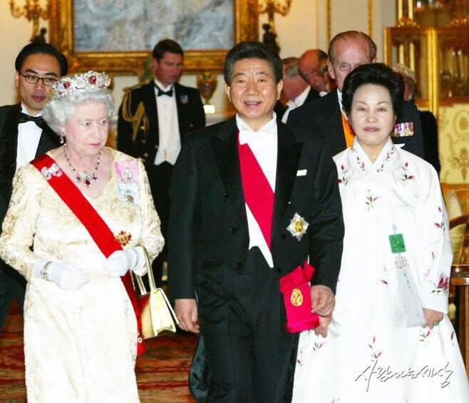 2004년 12월 당시 노무현 대통령과 영부인 권양숙 여사가 영국 엘리자베스 2세 여왕과 함께 런던 버킹엄궁에서 열린 국빈 환영 만찬에 참석하고 있다 (사진=노무현재단)