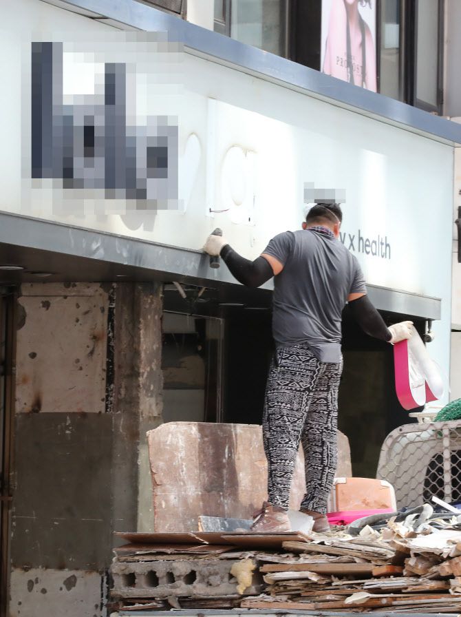 지난 20일 오전 서울 중구 명동의 상점 간판이 제거되고 있다. (사진=연합뉴스)