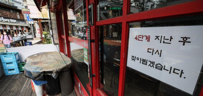 신종 코로나바이러스 감염증(코로나19) 4차 대유행 확산세가 지속함에 따라 정부가 수도권의 사회적 거리두기 4단계, 비수도권 3단계 유지를 발표한 20일 오전 서울 서대문구 신촌 거리의 한 음식점에 ‘거리두기 4단계’ 후 영업을 재개한다는 안내문이 붙어 있다. (사진=연합뉴스)