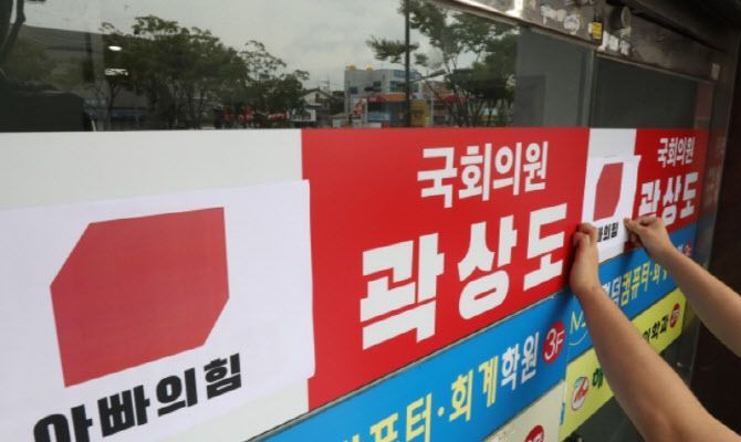 지난달 29일 오전 대구경북대학생진보연합 회원들이 아들의 퇴직금 50억원 논란으로 국민의힘을 탈당한 대구 남구 곽상도 의원 지역구 사무실 앞에서 국민의힘 당 로고 위에 ‘아빠의힘’이라고 쓰여진 로고를 붙이고 있다. (사진=뉴스1)