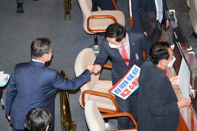 문재인 대통령이 25일 서울 여의도 국회 본회의장에서 2022년도 예산안 시정연설을 마친 뒤 성남 대장동 개발사업 특검 수용을 촉구하는 손팻말을 든 국민의힘 김기현 원내대표와 인사하고 있다.(사진=연합뉴스)