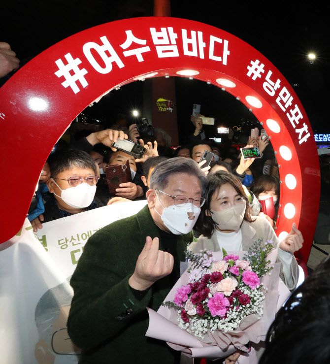 이재명 더불어민주당 대선후보가 생일인 27일 전남 여수시 하멜로 여수 핫플레이스 낭만포차거리를 부인 김혜경 씨와 함께 방문, 지지자들에게 하트 인사를 하고 있다 (사진=연합뉴스)