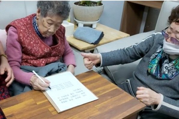 강일출(왼쪽) 할머니가 21일 나눔의집에서 서명하는 모습.(사진=일본군위안부ICJ회부추진위 제공)