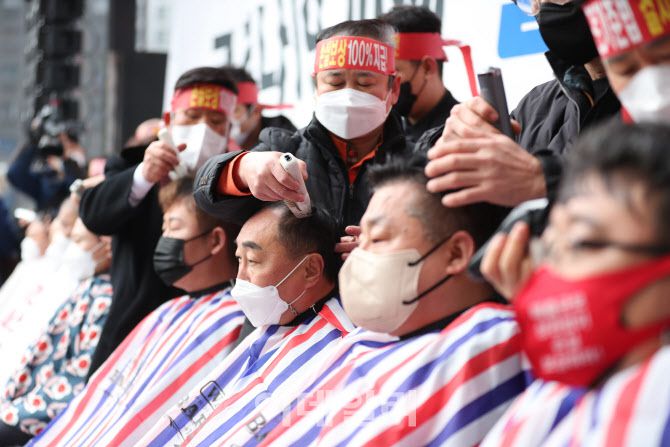 [이데일리 노진환 기자] 25일 오후 서울 여의도 국회 앞에서 코로나피해자영업총연합 소속의 자영업자 대표들이 정부의 코로나19 피해 실질적 보상을 촉구하며 삭발을 하고 있다.