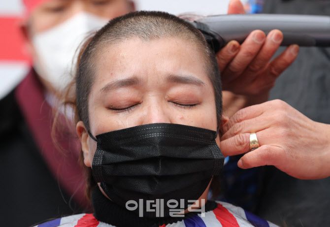 [이데일리 노진환 기자] 코로나피해자영업총연합 소속의 자영업자 대표가 25일 오후 서울 여의도 국회 앞에서 삭발을 하는 도중 눈물을 흘리고 있다.