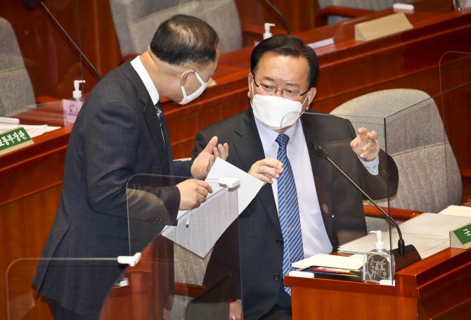 김부겸(오른쪽) 국무총리와 홍남기 경제부총리 겸 기획재정부 장관이 8일 오전 국회에서 열린 예산결산특별위원회 전체회의에서 대화하고 있다. (사진=연합뉴스)