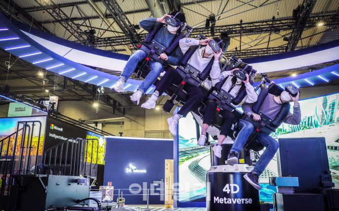 2월 28일(현지시각) 스페인 바르셀로나에서 개막한 ‘MWC 22’에서 참관객들이 SK텔레콤 부스에 설치된 4D 메타버스 체험 기기에 탑승해 UAM을 체험하고 있다. SKT 제공