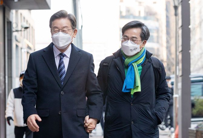이재명 더불어민주당 대선 후보와 김동연 새로운물결 대선 후보가 1일 오후 서울 마포의 한 카페에서 회동한 후 손을 잡고 함께 이동하고 있다. 김 후보가 새로운물결 상징색인 초록색과 파란색 목도리를 두른 모습.(사진=더불어민주당 선대위)
