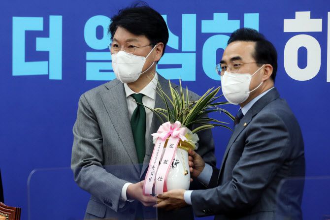 박홍근 더불어민주당 신임 원내대표(오른쪽)가 25일 서울 여의도 국회 원내대표 회의실에서 장제원 대통령 당선인 비서실장으로부터 윤석열 대통령 당선인의 축하 난을 받고 있다. (사진=연합뉴스)