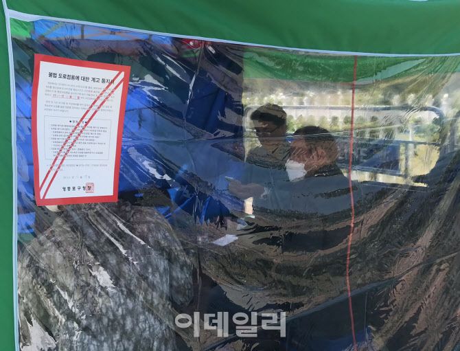 김진태 전 의원이 17일 단식 현장을 찾은 원주 국민의힘 책임당원들과 이야기를 나누고 있다. 천막에는 “도로를 불법 점유해 시민 불편을 초래하므로 15일까지 자진정비하라”는 영등포구청장 공문이 붙어 있다.(사진=김보겸 기자)