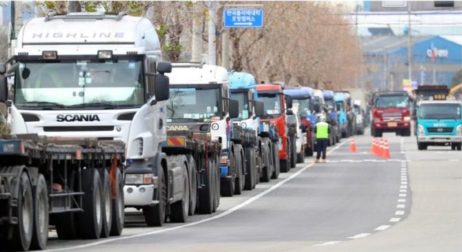 화물연대 파업이 이어진 지난 5일 경북 포항시의 한 도로에서 갓길에 줄지어 서 있는 화물차들 옆으로 운행 중인 유류 운반차, 화물차가 지나가고 있다.(사진=연합뉴스)