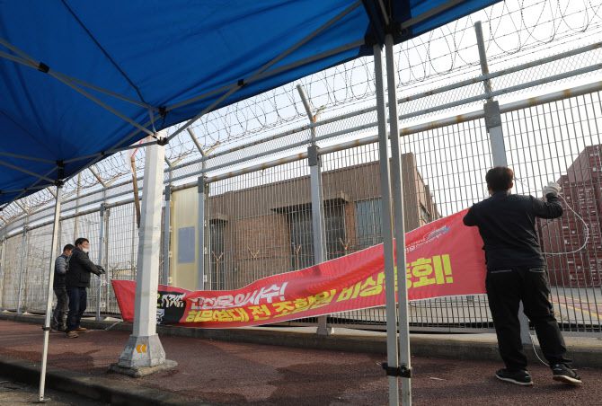 민주노총 공공운수노조 화물연대본부의 집단운송거부(총파업) 16일째를 끝으로 파업 종료를 결정한 9일 오후 경기 평택시 포승읍 평택항 인근에 설치된 현수막을 화물연대 조합원들이 철거하고 있다. (사진=뉴스1)