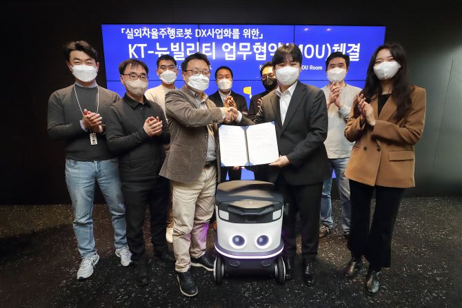 이상호 KT AI Robot사업단장(왼쪽에서 네번째)과 이상민 뉴빌리티 대표(왼쪽에서 일곱번째) 등 협약식에 참석한 관계자들이 기념사진 촬영하는 모습