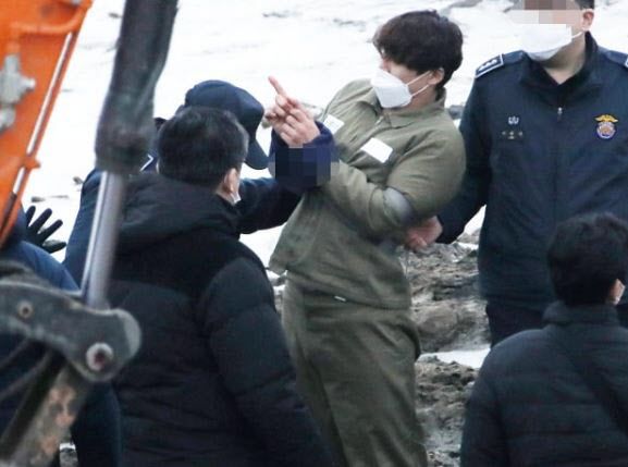 택시 기사와 동거녀를 살해한 혐의로 구속된 이기영이 6일 오후 경기도 파주 공릉천변에서 검찰 관계자들에게 시신을 매장했다고 진술한 부근을 손으로 가리키고 있다. (사진=연합뉴스)