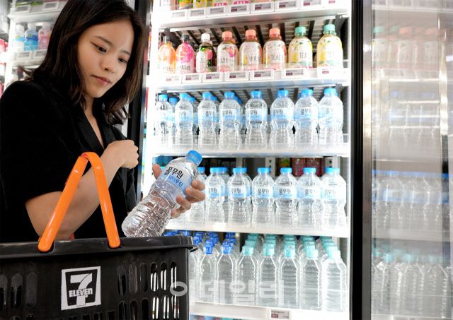 세븐일레븐을 찾은 고객이 100원짜리 생수를 구매하고 있다. (사진=코리아세븐)