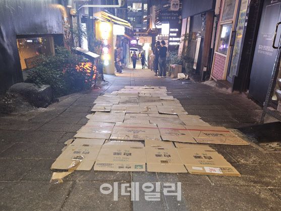 서울 용산구 이태원 세계음식거리 골목에 27일 미끄러움을 막기 위한 종이상자가 깔려 있다.(사진=이영민 기자)