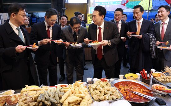 윤석열 대통령이 6일 부산 중구 깡통시장에서 이재용 삼성전자 회장 등 기업 총수들과 떡볶이 등 분식을 시식하고 있다. (사진=연합뉴스)