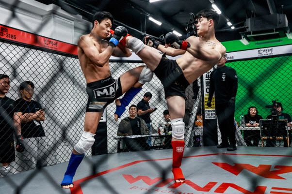 KMMA 초대 라이트급 챔피언 황준호(23·블랙리스트MMA, 오른쪽)가 도전자 곽동훈(23·포항팀매드)에게 오른쪽 헤드킥을 날리고 있다. 사진=KMMA