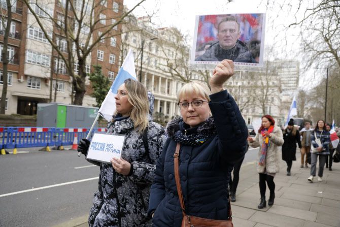 25일(현지시간) 영국 런던에서 러시아의 우크라이나 공격에 항의하는 시위에서 한 여성이 사망한 러시아 야당 지도자 알렉세이 나발니의 사진을 들고 있다.(사진=로이터)