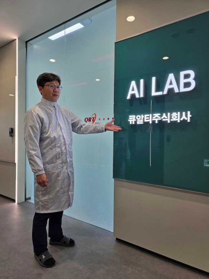 ‘큐알티 비전연구소’에 있는 ‘AI LAB’. 정한철 큐알티 수석연구원(프로젝트협력팀장)이 AI반도체 시험평가 장비 앞에서 포즈를 취하고 있다. 사진=큐알티 제공