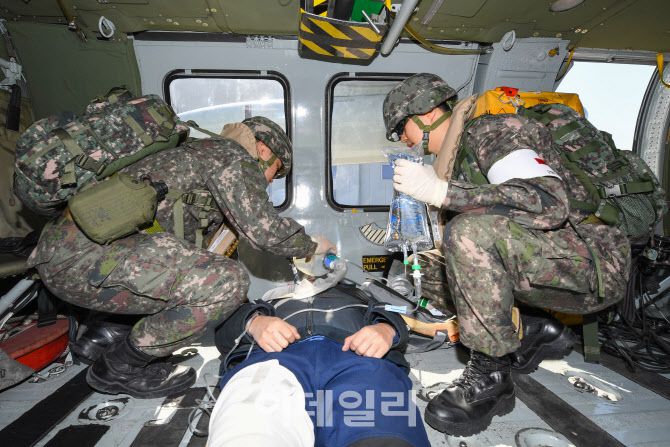 전시 한미 연합 의무지원훈련에서 해군 해상기동헬기(UH-60)로 이동한 해군 2함대 군 의료진이 덕적도에서 발생한 외상환자를 응급조치 하고 있다. (사진=해군)