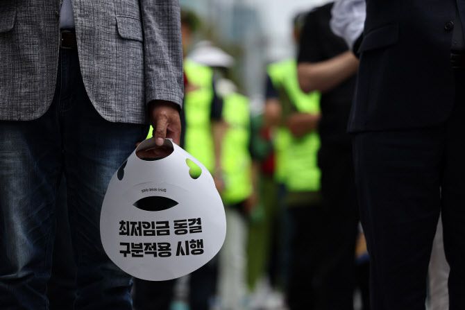 25일 오후 국회의사당역 인근에서 소상공인연합회 주최로 열린 최저임금 제도개선 촉구 결의대회에서 참석자들이 묵념하고 있다. (사진=연합뉴스)