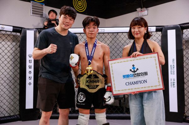 KMMA 플라이급 1차 타이틀 방어에 성공한 초대 플라이급 챔피언 이영웅(가운데)과 김대환 KMMA 대표(왼쪽), 후원사 FBS‘M 빅토리아 윤 디렉터가 함께 기념촬영을 하고 있다. 사진=KMMA