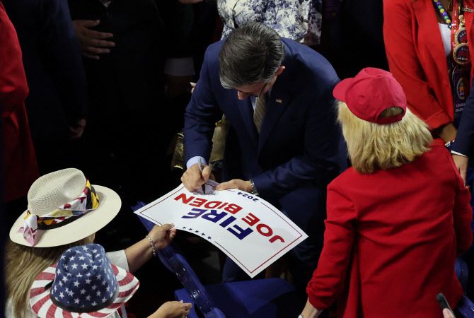 18일(현지시간)  미국 위스콘신주 밀워키의 피서브 포럼에서 열린 공화당 전당대회 4일차 행사에서 마이크 존슨 하원의장이 ‘조 바이든 해고’ 손팻말을 든 참석자들에게 사인을 해주고 있다. (사진=로이터)