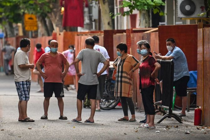 코로나19 바이러스가 유행하던 지난 2022년 코로나 봉쇄 조치가 적용된 중국 상하이의 한 거리에서 주민들이 마스크를 쓰고 모여 있다. (사진=AFP)