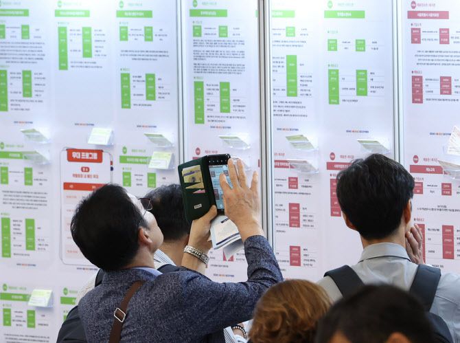 2024년 서울 중장년 일자리박람회에서 한 구직자가 채용공고 게시물을 휴대전화로 사진찍고 있다. (사진=연합뉴스)