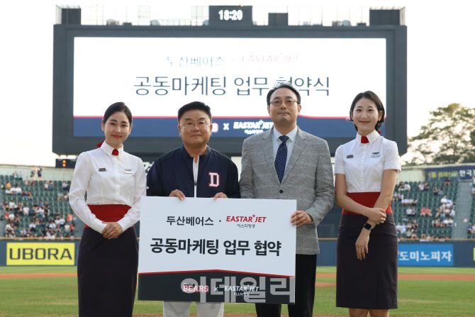 이스타항공 이경민 커머셜본부장(오른쪽)과 두산베어스 김태룡 단장(왼쪽), 이스타항공 객실승무원이 협약식 후 기념 촬영을 하고 있다.(사진=이스타항공)