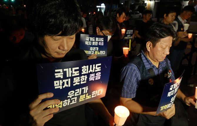 지난해 9월 14일 저녁 신당역 10번 출구 인근에서 열린 신당역 살인사건 1주기 추모 문화제에서 참가자들이 촛불을 들고 묵념하고 있다. (사진=연합뉴스)