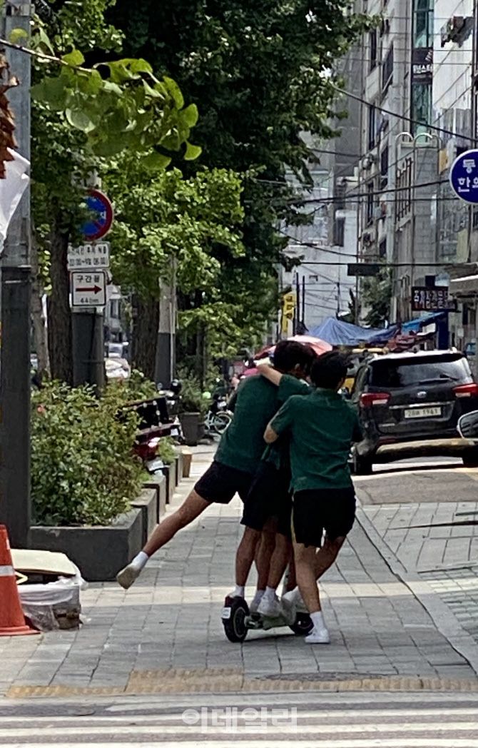 지난 5일 오전 서울 양천구 목동 학원가에서 청소년 4명이 하나의 전동킥보드를 타고 있다. (사진=박동현 기자)