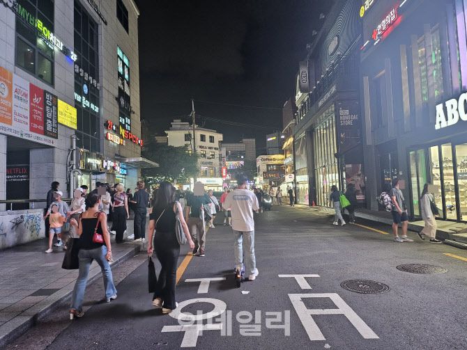 지난 5일 늦은 오후 인파가 가득한 서울 마포구 홍대입구역 인근에서 한 시민이 헬멧을 쓰지 않은 채 전동킥보드를 타고 있다. (사진=김형환 기자)