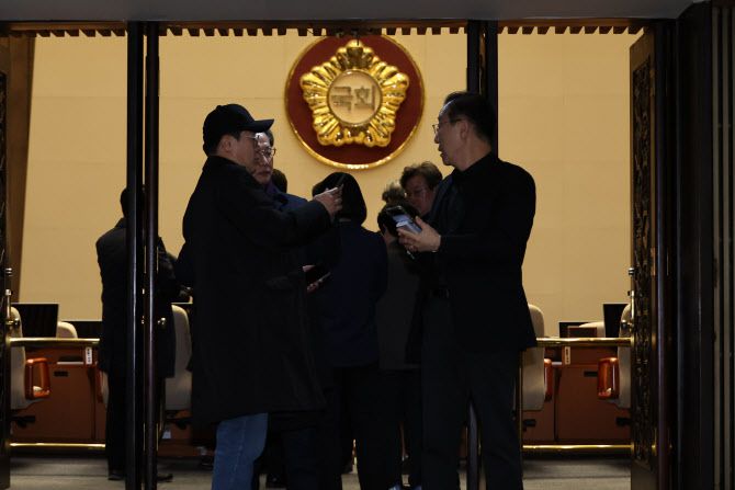 윤석열 대통령이 비상계엄을 선포한 3일 밤 박찬대 더불어민주당 원내대표를 비롯한 의원들이 국회 본회의장에 긴급 소집돼 상황을 파악하고 있다. (사진 = 연합뉴스 제공)