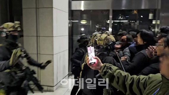 지난 3일 심야 서울 여의도 국회의사당 내에서 군인과 대치 중인 시민이 상황을 촬영하고 있다. (사진=독자 제공)