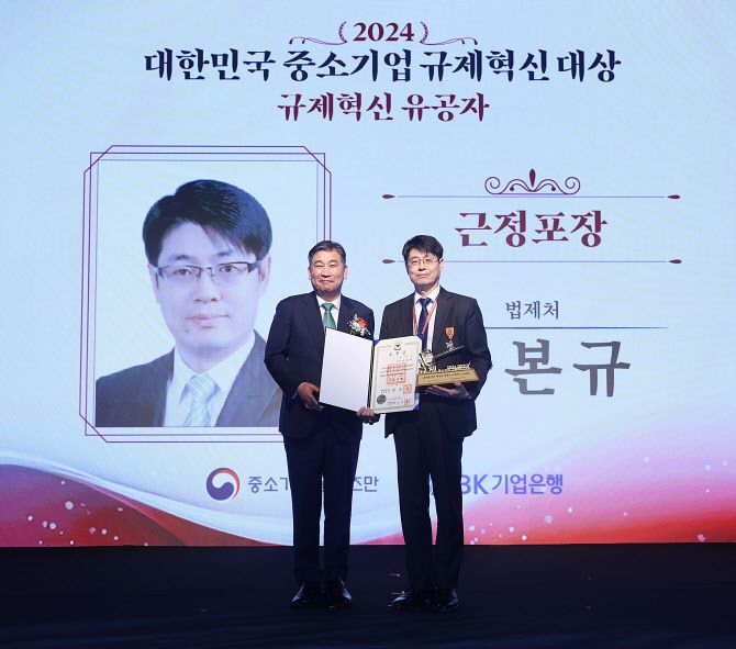 최승재 중소기업 옴부즈만이 16일 서울 중구 더플라자호텔에서 열린 ‘2024 대한민국 중소기업 규제혁신 대상’에서 법제처 구본규 부이사관에게 근정포장을 시상하고 기념촬영을 하고 있다.(사진=옴부즈만)