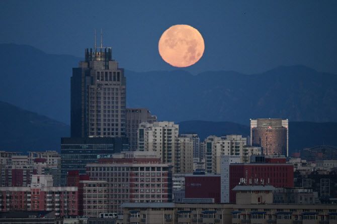 중국 베이징 도심의 건물들 뒤로 달이 지고 있다. (사진=AFP)
