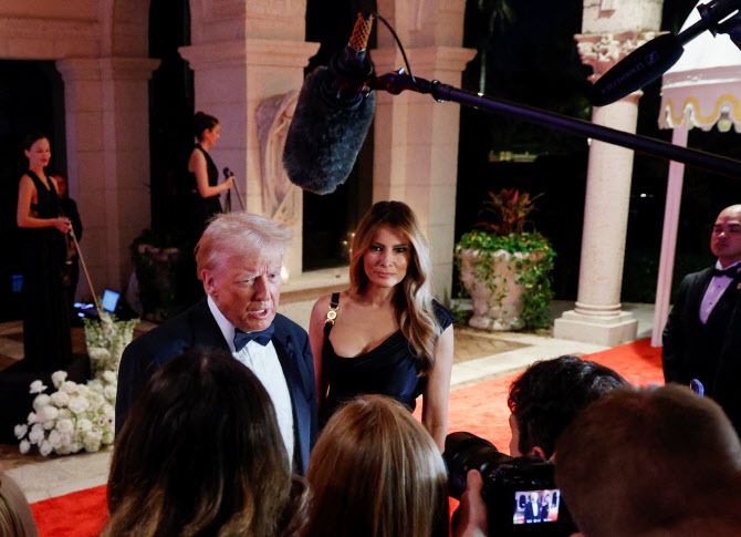 U.S. President-elect Donald Trump, accompanied by his wife Melania, attends a New Year‘s Eve event at Mar-a-Lago in Palm Beach, Florida, U.S., December 31, 2024. REUTERS/Marco Bello
