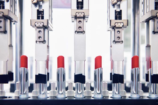 코스맥스 평택 2공장 자동화 설비에서 립스틱 제품 용기에 로봇이 내용물을 충전하고 있다. (사진=코스맥스)