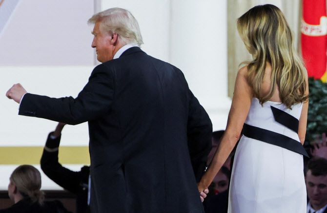 도널드 트럼프 미국 대통령이 영부인 멜라니아 트럼프와 함께 20일(현지시간) 미국 워싱턴에서 열린 취임 기념 총사령관 무도회에 참석하며 제스처를 취하고 있다.(사진=로이터)