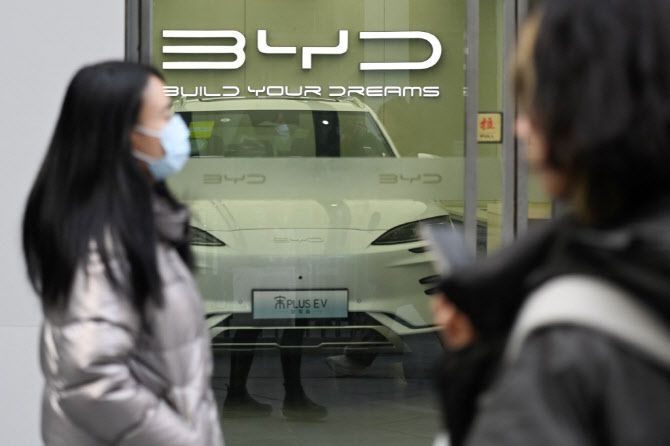 중국 베이징에 위치한 BYD 전시장 앞을 시민들이 지나가고 있다. (사진=AFP)