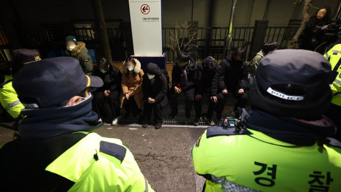 윤석열 대통령의 영장실질심사가 열린 18일 오후 서울 마포구 서울서부지방법원에서 윤 대통령의 석방을 촉구하며 법원 담장을 넘어 들어온 청년들이 경찰에 붙잡혀 있다.(사진=뉴스1)